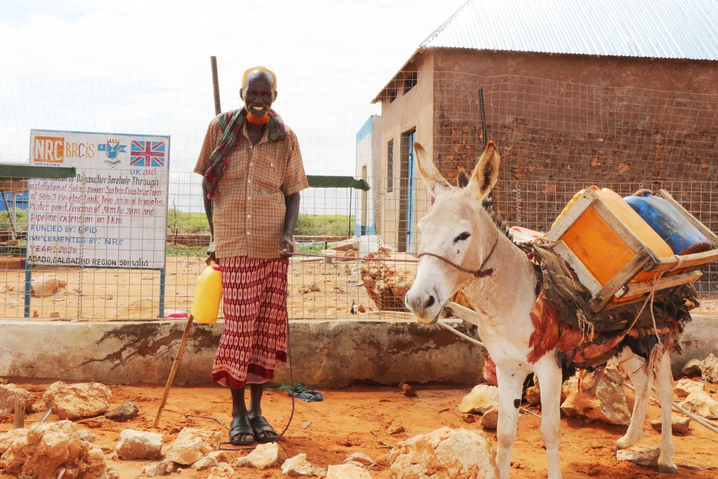 Hassan Dhore – 70 years old father collects water at Dhagahdher water point rehabilitated by NRC through BRCiS project and funded by FCDO. Photo: Abdulkadir/NRC.