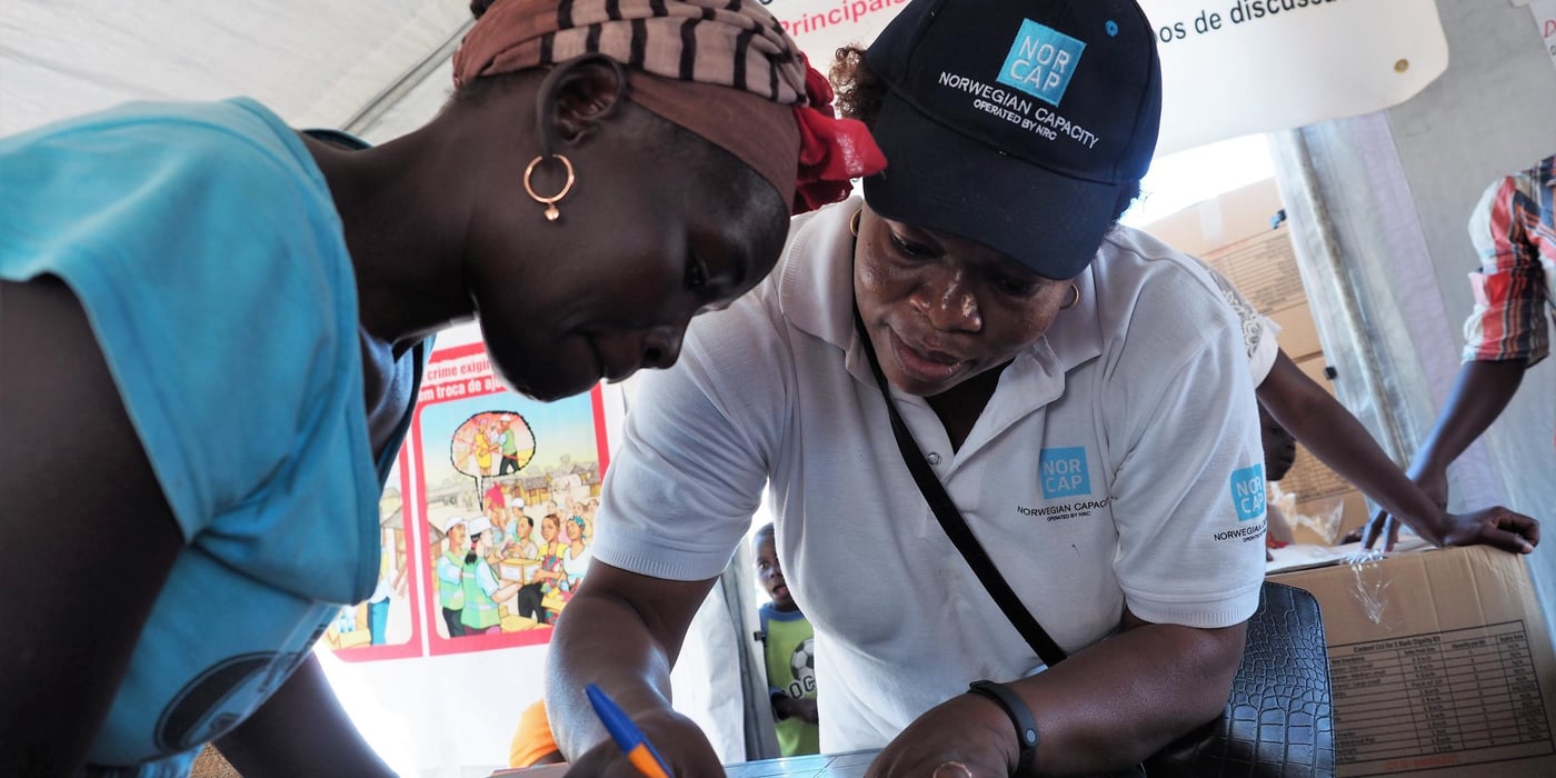 NORCAP gender-based violence specialist, Felicité Molengar, helping a woman register for receiving a dignity kit after cyclone Idai in Mozambique.