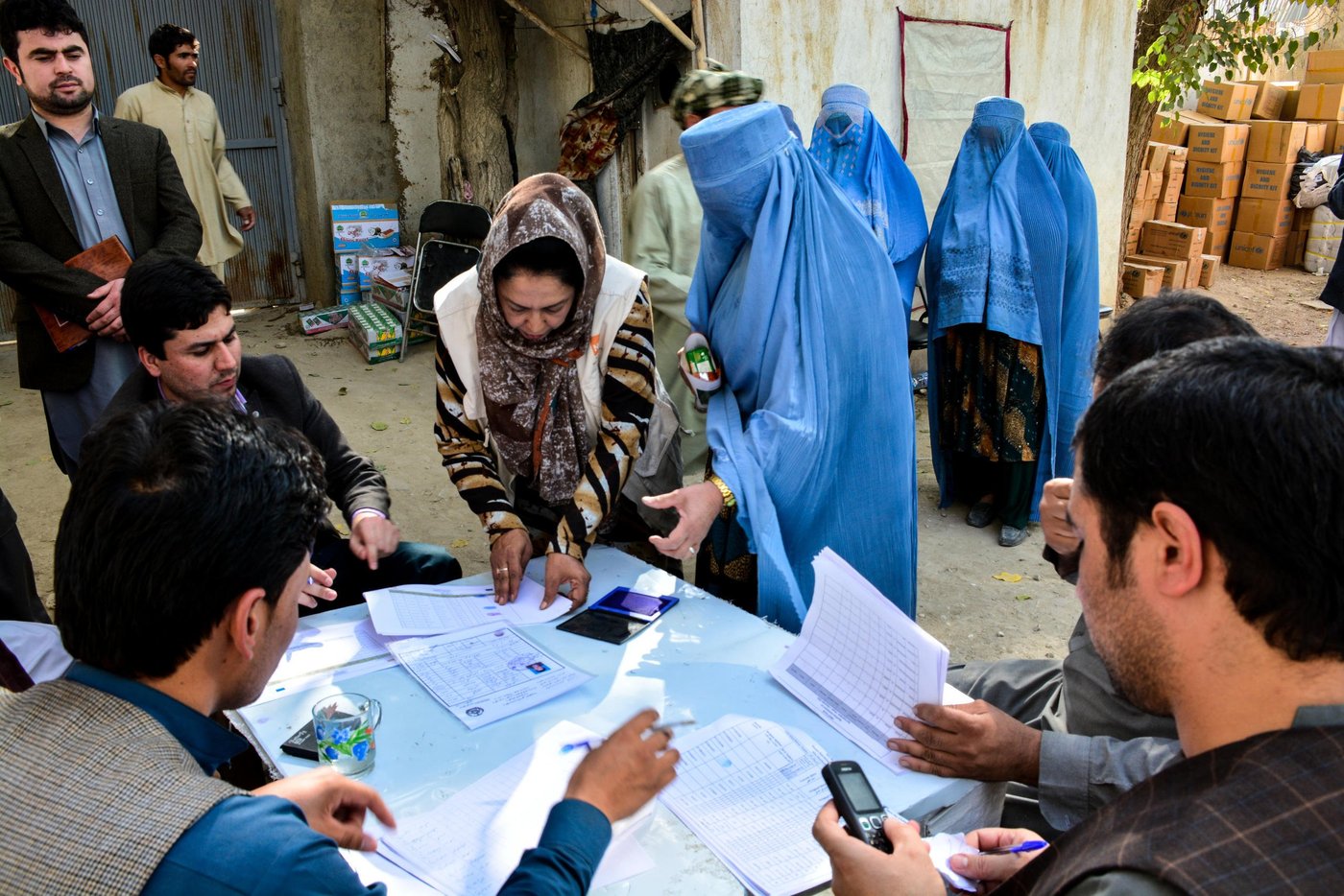 Emergency field assistant for Norwegian Refugee Council in Faryab, Nafisa Barakzai, helping displaced women to add their finger print to a list of people who will receive unconditional cash grants for their daily life expenses. (Photo: Enayatullah Azad, NRC 2016)