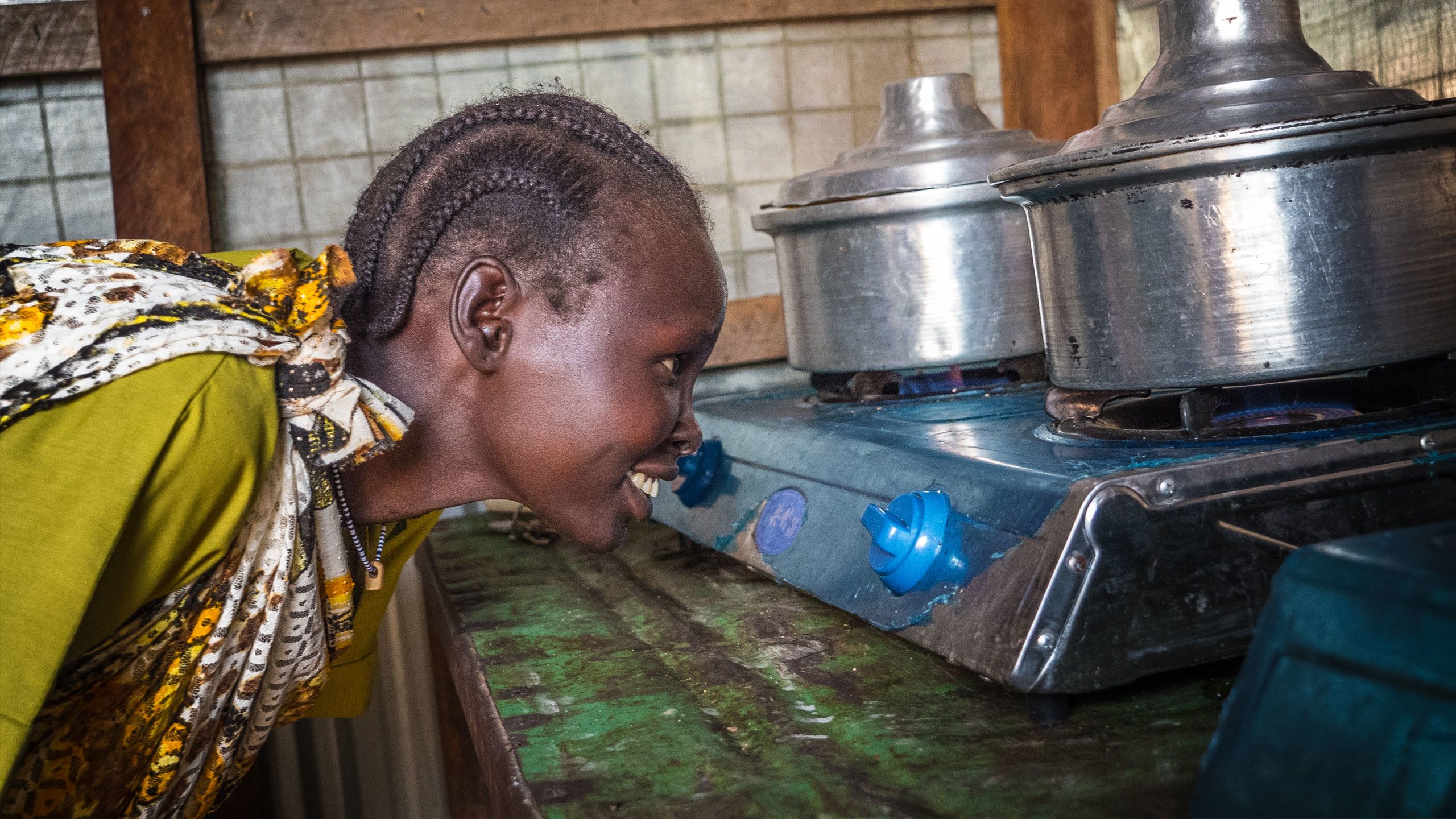 Sarah Pamed checking the gas flame stemming from a biogas plant at the refugee camp in Malakal, South Sudan.