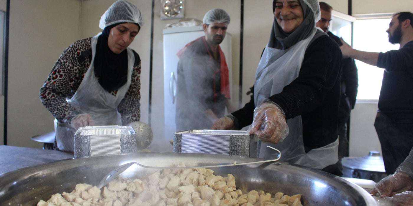 Khitam, a 54-year-old woman from Syria, lives in one of the biggest refugee settlements in Lebanon, together with more than 1,500 refugees. She is one of seven refugee women cooking meals that are distributed to the refugees living in the settlement.
"I work to support myself. My situation is dire and I don’t have anyone else who can provide for me," says Khitam.
Thanks to the generosity of our private sponsors, the Norwegian Refugee Council (NRC) was able to provide funding to a local Lebanese organisation, Union of Relief and Development Associations (URDA), that set up a kitchen in a refugee settlement in the Bekaa Valley in eastern Lebanon. URDA employs refugees to cook the food and distribute the meals to thousands of refugees living in tented settlements.
Fled from Syria six years ago
Six years ago, Khitam fled from Homs in Syria to Lebanon with her husband and children. Her husband died three years later, leaving her alone.
"My children have families and are barely able to feed their own children. I could never ask them to provide for me as well," she says.
She is happy to be a part of the cooking group in the camp.
"Cooking food for other refugees makes me happy and the salary makes me able to support myself. It’s heavy work – we do everything from cutting chicken and boiling rice, to cleaning and preparing food boxes for over 1,000 people."
Over 1,500 meals for 300 refugee families
In March 2019, NRC supported the preparation of over 1,500 meals for 300 refugee families, the majority of whom were evacuated from their homes after the winter storms. Some of them have still not been able to return to their homes as their tents are being rehabilitated.
Khitam and the other women receive a lot of positive feedback from people saying they’re enjoying their food.
Through the cooking, the women come together and are able to keep their mind off their current lives as refugees.
"Knowing I contribute to put food on the table for other refugee families and to feed their children makes it worth all the hard efforts I put into my cooking,” says Khitam.
Credit: Racha El Daoi/NRC