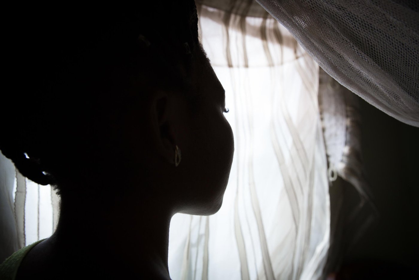 “When the crisis started I was going to school and at the same time helping my mom with her business. But, the fighting made things tough, business was tight, it was hard. I continued to go to school but the boys would come and meet us in school and beat us, then drive us away from school and force us to go back to the house. I have been beaten not once, not twice, but many times by those boys. They don’t want us to go to school, to make a future for ourselves and the society. If we go, they will beat you up and attack your family. So, I had to stop school because my family was really in danger,” Kelly, 21 years old, tells us when we meet her in November 2019.
The boys are what the armed separatists are called locally in the North West province. In 2016, as English-speaking lawyers, students and teachers began protesting what they saw as their cultural marginalisation and under-representation in the central government, the Government forces hit back with a hard hand. Several armed separatist groups emerged and eventually declared independence 1. October 2017. They called their new country Ambazonia.
Kelly lived in a big compound with her mom, dad, her siblings and extended family. Her parents ran a business and they had a farm.
“I had many people around me back then, but due to the crisis I have just a few left.”
On 11. February 2016, on the National Youth Day, clashes were intense in her village. The separatist did not recognise the youth day and put up the Ambazonia flag and the military retaliated.
“The military came to our compound. The gate was closed, but they climbed the fence and entered. They shot at anybody they saw, they never cared to know who was who, they were just shooting. My younger sister and myself were hiding under a bed. My uncle was also there and they just entered the room and shot him, thinking he was one of those boys. They shot him right in front of me and my sister. After that, there was no way we could sleep in the house, so we fled to the bush and slept there. In the morning we came back and took my uncle to the morgue to prepare the funeral. That’s when my mom and my dad decided that we should look for another way for me to go to school, because staying in the village, doing nothing, will not help me so it’s better I leave”.
Three months later, at the age of 18, Kelly left her home to go to Yaoundé. She found a place to live and started to work to save up money to continue her education and slowly built a new life for herself over the next three years. She felt safe again. Then, everything changed.
“I lost my dad 5. November. This month. I was not in the village when it happened, but they told me that he got up at night to ease himself. We do not have a toilet inside the compound so he had to go outside. Unfortunately, he was shot that night. He was taken to the hospital, but they could not save him.”
Every bullet victim is automatically investigated in the area, so the police came to talk to the family and her mother tried to answer all their questions. They found out it was the separatists, the boys, who had shot him. The situation was very intense in the village in that period. Kelly travelled from Yaoundé to the village for the funeral and then quickly returned to the capital due to the fighting.
Two days after her dad was killed, another crisis hit the family. Kelly’s older sister got kidnapped by the boys. The kidnappers asked for 2,5 million francs in ransom for the group. The family tried to raise 500 000 francs. Kelly gave 50 000 francs that she had managed to save during her time in Yaoundé. These were the money she would use for her school fees, but instead she had to spend them to pay for her dad’s funeral and now her sister’s kidnapping. Together, the family managed to find money and her sister was released.
“My sister was badly beaten. All her body; wounds, wounds, wounds. Fortunately, she was not raped, because those boys don’t sleep with girls who have their period. So, that was the only way she was saved from those guys. It was a miracle.”
After Kelly’s sister was released, she fled for safety to Bamenda, a bigger town in the area, where she is trying to attend some classes now and then. Kidnappings for ransom have become a regular thing in the province. Armed separatist groups have killed, tortured, assaulted, and kidnapped dozens of people, including students, teachers, clergy, and administrative and traditional authorities.
“I think the boys are kidnapping because they need money to purchase weapons,” Kelly states.
While her sister was still missing, Kelly received yet another call, this time from an unknown number, telling her she had to come back to the village for an emergency. They did not say what had happened, just that she had to come as fast as she could. Kelly was afraid she would lose her job if she left so soon after she had just been away for her dad’s funeral, but had to go and risk it.
“As I entered the compound, everyone was crying. The first thing I asked was ‘Where is my mom?’ Everybody was crying in silence. They asked me to sit down, but I said ‘No, I don’t want to sit down, I want to see my mom.’ Then they told me that my mom had passed away. I had a shock. The next thing I remember is waking up in the hospital. I spent two days there.”
“My mom was shot by those boys due to the investigation after my dad was killed. They know our house. They came inside our compound and asked for her. They shot her with four bullets to her body and left. No one else was shot. My mom was their main target. The boys were angry, because she spoke to the police. They don’t want us to have anything to do with the police.”
In less than a week, both Kelly’s parents had been killed. Her sister had been kidnapped.
She did not feel safe.
“At the funeral ground the boys kept looking at me. Just looking, looking, looking. I felt like I was going to be the next target. I had to leave the village, cause my life was in danger. It was a lot of gunshots. Everywhere. Everywhere! So, I managed to take the bush backroad and was lucky to find a taxi and I took it straight to Bamenda and then back here to Yaoundé. I told no one I was back. I just stayed inside for a week, mourning my mom and my dad. No school. No work. Just mourning them.”
In this period, she was also told to move out from the room she shared with a friend and this one’s sister who felt it had become too crowded. Now, Kelly needs to find a new place to rent, but with soaring housing process in the capital and her savings gone, it’s not an easy task.
“I lost my dad. I lost my mom. My sister was kidnapped. So, all my savings are gone. I’m back to square one. Even to have a meal per day is difficult. I tried to get an advance from my boss. I tried to borrow money from friends so I can afford to move into a new place.”
Kelly now works in a school canteen five days a week. She leaves the house at 5am, works, comes back at 2pm. Rests for a little while, then goes to evening school until 9pm. At night she can seldom afford to eat, so she goes to bed and gets up again at 2am to study when the house is quiet.
“I really need to go to school. Education is the key to life. Education is the highest thing. It was my parents’ dream for me, to go to school, to become something great in life that make you stand out in a population and talk like a woman. Even though they are no more, I have to work hard for myself and achieve my dreams.”
Kelly dreamt of becoming a lawyer, or a medical doctor, but now she is thinking accounting or management is more realistic. Or, play the American lottery and see if she can leave the country.
“Even though it’s hard to lose two parents at the same time, it’s nothing I can do. All the things they used to do for me, I now need to do alone. It’s hell. But, this is what my fate has decided for me. I just need to move on with life.”
Photo: Ingebjørg Kårstad/NRC