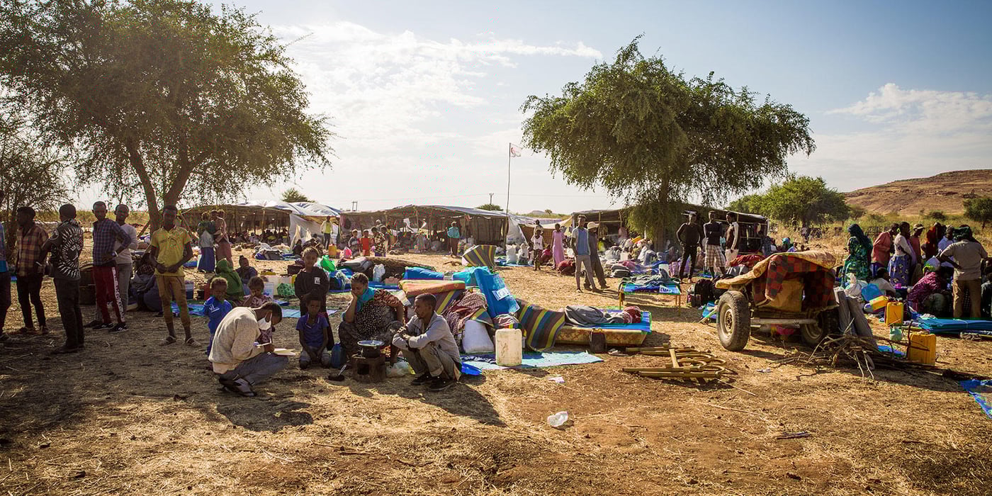 New arrivals are waiting at the entrance to Um Rakuba camp in Sudan, after being transferred from the border areas.