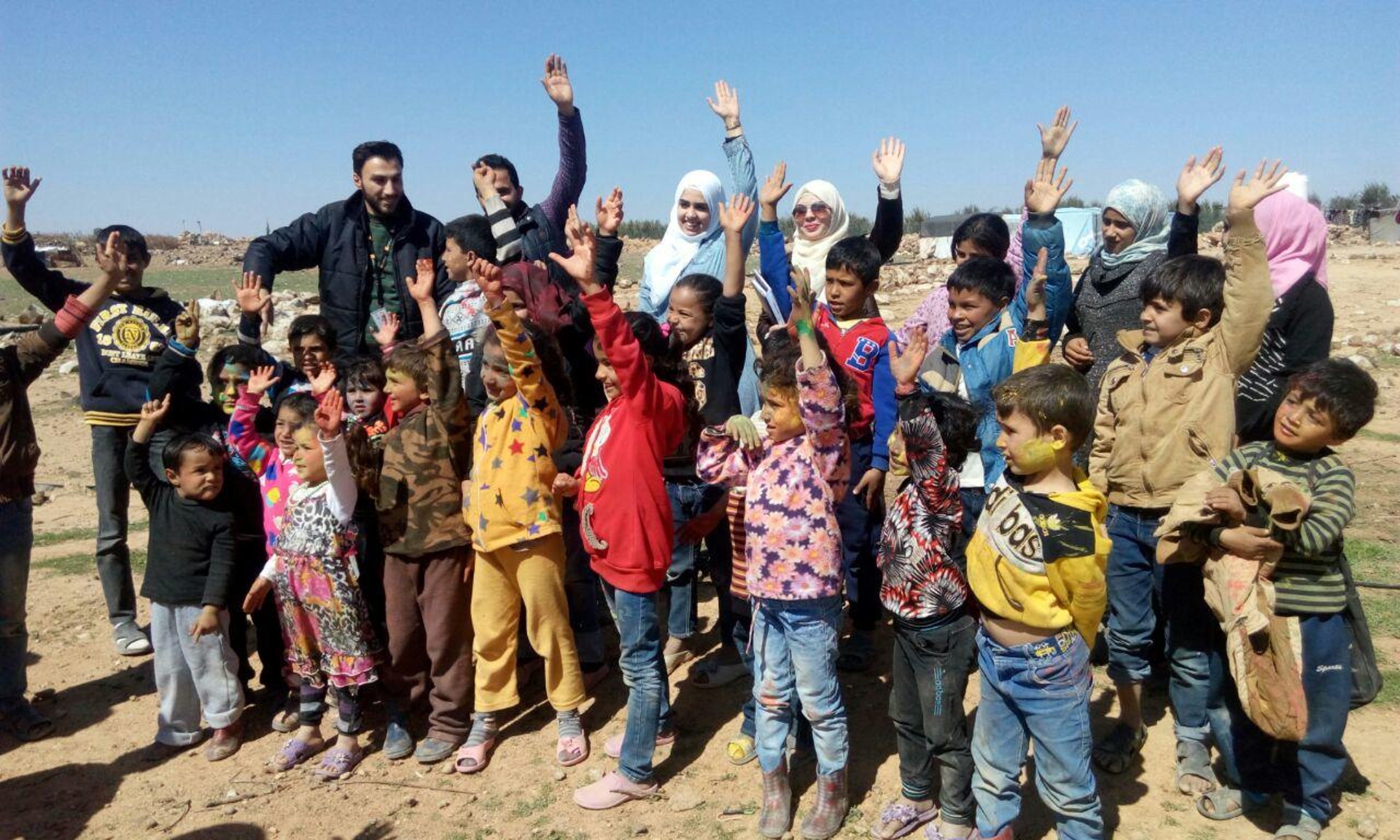 NRC ICLA staff with children living in the informal tented settlement in Mafraq, Jordan.