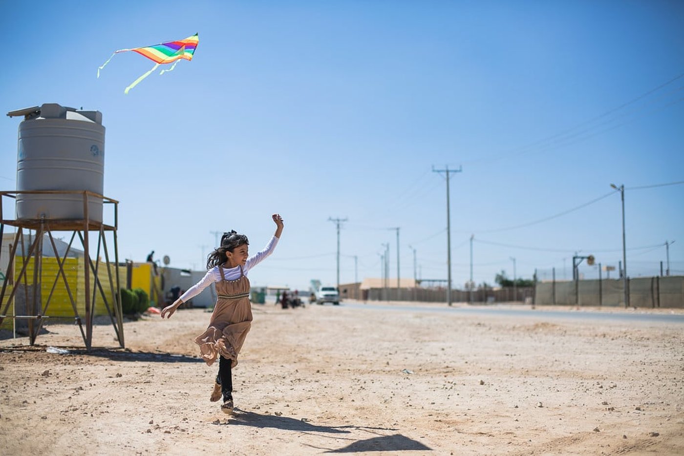 Yamama, 9 years old, playing with her kite at Zaatari refugee camp, Jordan.