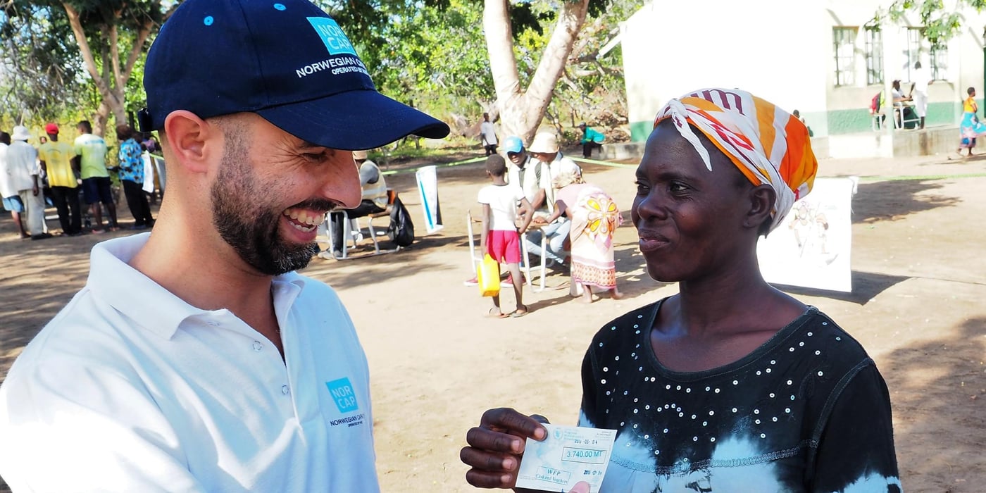 Ricardo Lobo, CashCap expert in Beira, Mozambique, talking to Elisa Pedro Manuel Malaua, who have just received her vouchers at a WFP distribution, as a response to the Cyclone Idai crisis in March 2019. (Photo: NORCAP/Ida Sem Fossvik)
