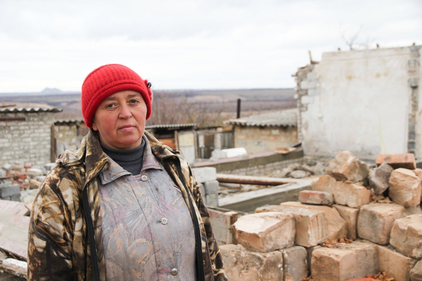 Jelena has had a tough life. She has live it the village Zolotarivka in eastern Ukraine her whole life, with a husband with drinking problems, a daughter and a son. Some years ago her son, who provided the whole family was killed in an accident. After that she has been living in this house with her daughter (28). During the shelling that lasted for 15 days, between 12th and 25th of July 2014, her house was hit by a rocket, and damaged so badly that it could not be rebuilt. The kitchen was the only room that was not completely demolished. The rest of the house had to be rebuilt.
When she returned and saw the damage, she said: “I want to die, they have destroyed my home and my life”.
Jelena has been moving around to stay with different friends for 18 months since the grenade hit. NRC has provided her with building materials, and the local community has given her some money to pay for the workers to help rebuild the house.
Now Jelena is looking forward to have her home rebuilt. She hopes that she can move in before winter. She says: “finally I have hopes in my life, I can get back to the life I had before”.
Quotes jelene (transcript from video interview)
This used to be my home. In the night between 13th and 14 of July it got destroyed. When I came home from the bomb shelter I was overwhelmed by emotions. I did not want to live, because I had no place to live anymore.
This used to be my home. In the night between 13th and 14 of July it got destroyed. When I came home from the bomb shelter and saw all these horrors. I was overwhelmed by emotions. I did not want to live, because I had no place to live anymore. Thanks to the NRC who helped me so much, I now have a hope. I hope that it will be rebuilt and I am waiting until it is rebuilt, so that I can live at home.
I am very thankful to NRC for their great help. Of course you helped very much and now the hope is emerging that I will live in my home. Thank you very much.
